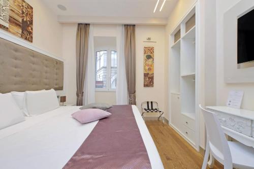 ローマにあるAlla Locanda Malandraのベッドルーム(白い大型ベッド1台、デスク付)
