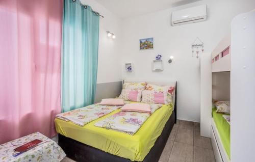 una piccola camera da letto con un letto con lenzuola gialle e rosa di Villa Dora ##2 a Crikvenica