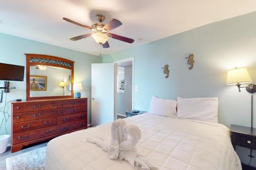 a bedroom with a white bed with a ceiling fan at Rehoboth Beach -- The Crest #303 in Rehoboth Beach