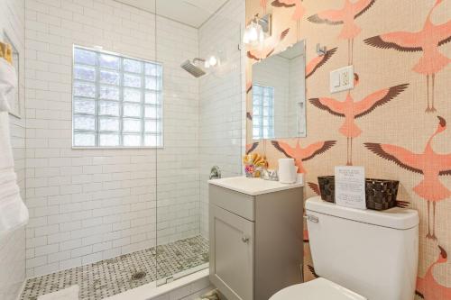 La salle de bains est pourvue de toilettes et d'une douche murale avec des oiseaux roses. dans l'établissement Pink Flamingo, à Dunedin