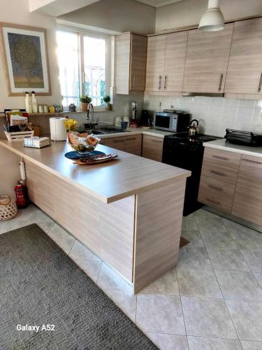 a kitchen with wooden cabinets and a counter top at Jimmy’s Beautiful Sparta Home in Sparti