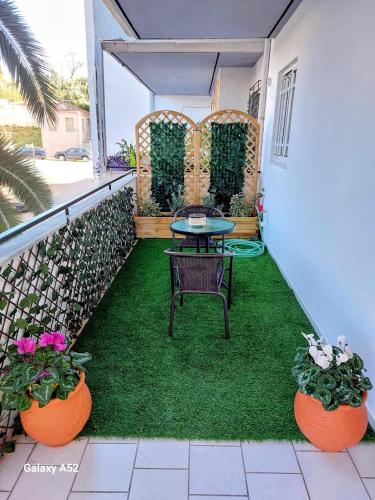 a patio with a table and two potted plants at Jimmy’s Beautiful Sparta Home in Sparti
