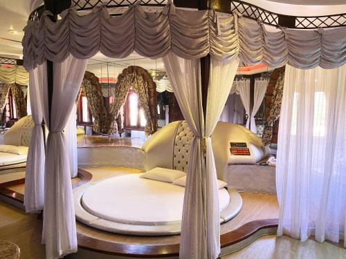 een slaapkamer met een hemelbed en gordijnen bij Motel Camelot in São Leopoldo