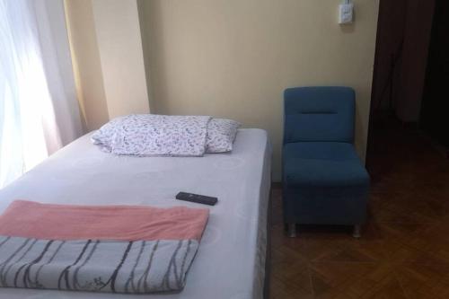 ein Schlafzimmer mit einem Bett und einem blauen Stuhl in der Unterkunft Kely 6 Apartamento 2do Piso in Lima