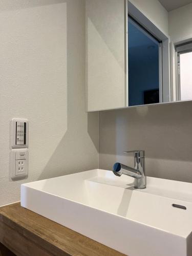 a bathroom with a white sink and a mirror at 天龍の宿 New Open一棟貸切Private Villa Arashiyama Tenryu-ji Temple徒歩2分 in Shimo saga