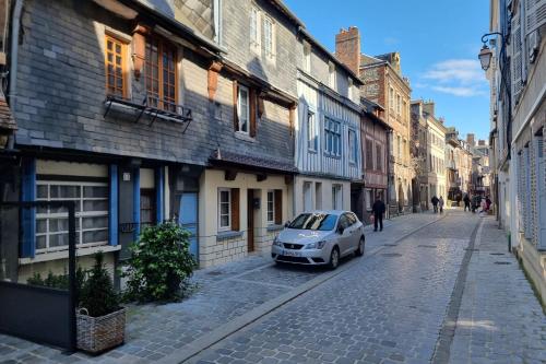 une petite voiture garée dans une rue pavée dans l'établissement EL CIRCO - Atypical studio - City Centre - Netflix - Near Parking, à Honfleur