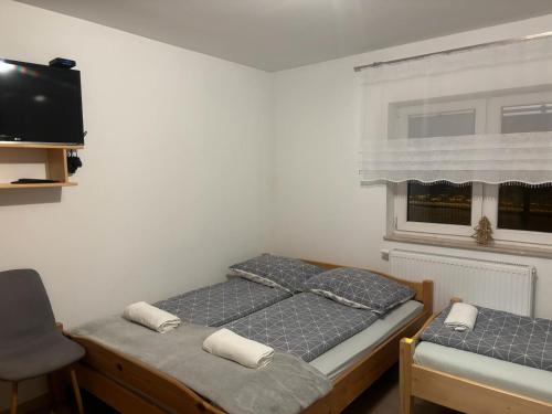 two twin beds in a room with a window at Domek nad Dunajcem in Krościenko