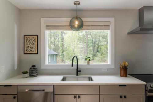 a kitchen with a sink and a window at Perch Eagle House: Creek access + mountain views in Boiceville