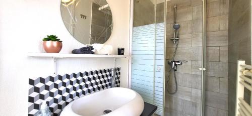 ein Badezimmer mit einem weißen Waschbecken und einer Dusche in der Unterkunft Primavera : Beau 2-pièces proche Paris, RER B 450m in Gentilly