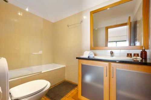 een badkamer met een toilet, een wastafel en een spiegel bij Spacious Apartment with Sea View in Lagos