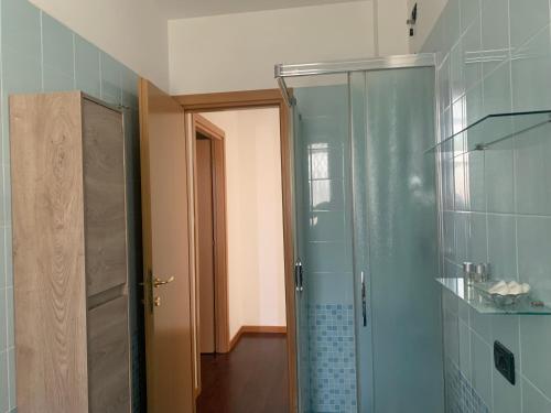 La salle de bains est pourvue d'une douche et d'une porte en verre. dans l'établissement Damo Stefania Blu Hause Marina, à Cavallino-Treporti