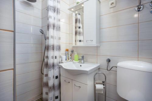 bagno con lavandino, servizi igienici e specchio di Villa Dora ##3 a Crikvenica