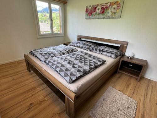 ein großes Bett in einem Zimmer mit Fenster in der Unterkunft See und Berge Family in Faulensee