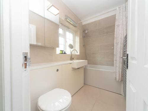 a white bathroom with a toilet and a sink at Lovely cosy gem with free parking Pass the Keys in Surbiton