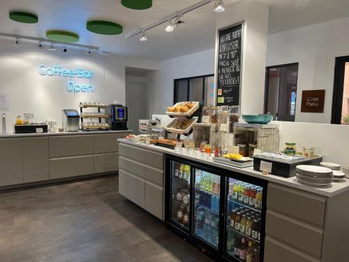 a bakery with a counter with food on it at Hôtel PB - Paris-Barcelone in Perpignan