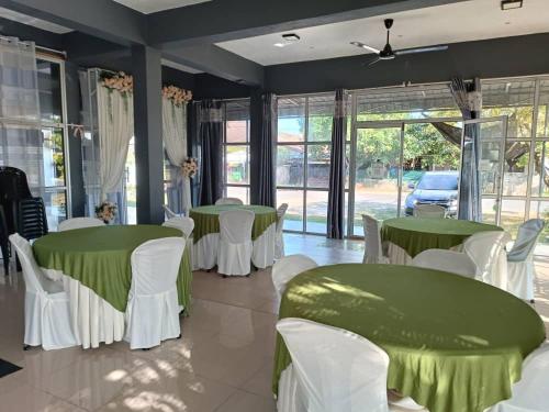 a room with green and white tables and chairs at VILLA ANJUNG TAMU in Kampong Pak Sabah