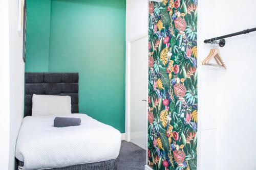 1 dormitorio con cama y pared verde en Duke's Den - Liverpool City en Liverpool