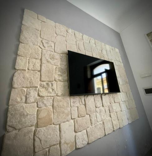 eine Steinmauer mit einem TV an der Wand in der Unterkunft Luxury home in Syrakus