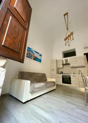 ein Wohnzimmer mit einem Sofa und einer Küche in der Unterkunft Luxury home in Syrakus