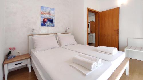 a bedroom with a large white bed with white pillows at Apartments Martin in Drvenik