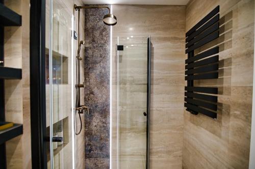 um chuveiro com uma porta de vidro na casa de banho em Apartament Bulwary317 em Oświecim