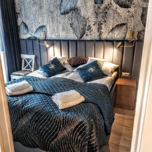 a bedroom with a bed with blue sheets and pillows at Apartament Bulwary317 in Oświęcim