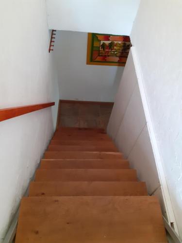 a staircase in a room with white walls and wooden floors at CountryHouse in Wardenburg