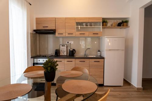 cocina con mesa, 2 sillas y nevera en Ophelia - New Modern Apartment with Spectacular Olympus View, en Litóchoron
