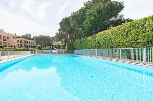 une piscine vide avec une clôture et des arbres dans l'établissement villa dans résidence à Cannes, à Cannes