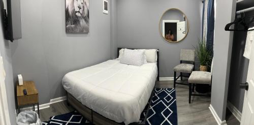 a small bedroom with a bed and a mirror at Feel at home when you’re away in Philadelphia