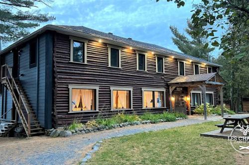 a log cabin with a picnic table in front of it at Le1613 - Bord de l'eau - Les chalets dans le nord in Val-David