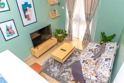 a living room with a couch and a television at COZY COOL ,WIFI 6 MINS WALK TO ACACIA MALL in Kampala