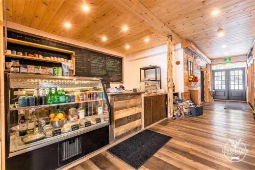 a restaurant with a counter with a drink refrigerator at Le1613 - Bord de l'eau - Les chalets dans le nord in Val-David