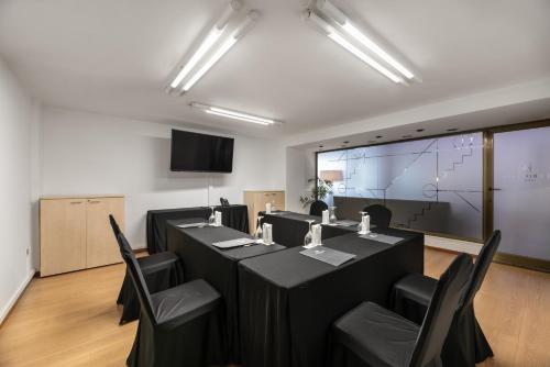 a conference room with tables and chairs and a projection screen at Eurostars Gran Hotel Lugo in Lugo
