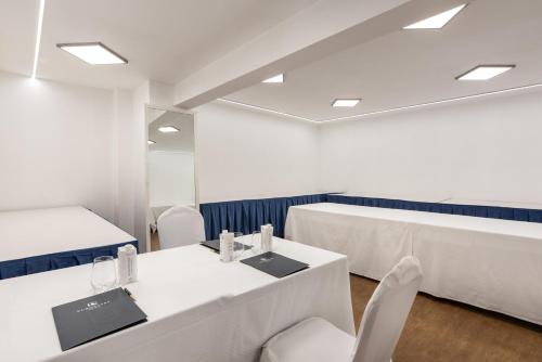 a conference room with white tables and chairs at Eurostars Gran Hotel Lugo in Lugo