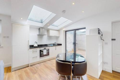 a kitchen with a glass table in the middle at 1 Bed House with Garden sleeps 4 - 10 min to Station in London