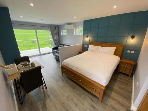 a bedroom with a bed and a table and a room at Laigh Letterpin Lodge in Girvan