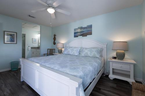 a bedroom with a white bed and a ceiling fan at Palmetto 306 in Orange Beach
