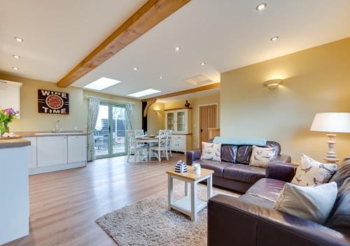 a living room with a couch and a table at Pheasant Lodge in Reepham