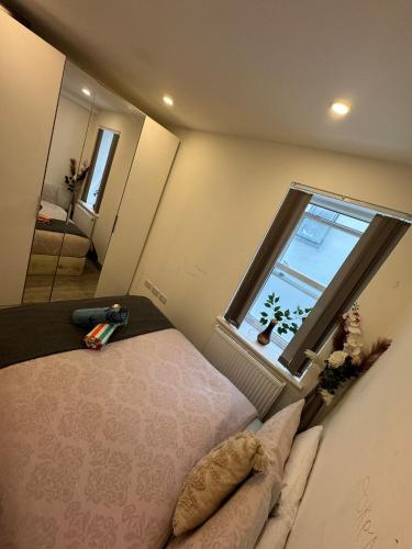 ein Schlafzimmer mit einem Bett und einem großen Fenster in der Unterkunft Forestroom in London