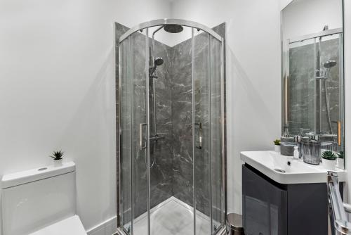 een douche met een glazen deur in de badkamer bij Lovely Penthouse in Worthing - Sleeps 6 in Worthing