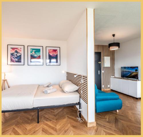 sypialnia z łóżkiem i niebieskim krzesłem w obiekcie Chez Fan & Alex St Julien w mieście Saint-Julien-en-Genevois