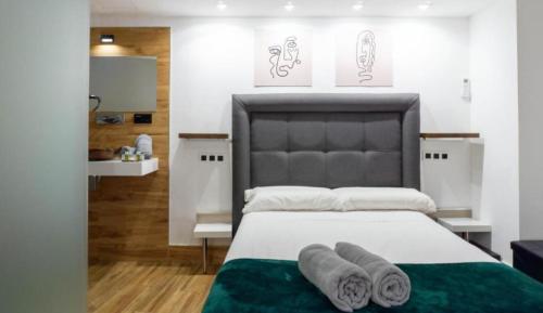 a bedroom with a large bed with towels on it at Ilustre Rooms by Beehive Vacances in Málaga