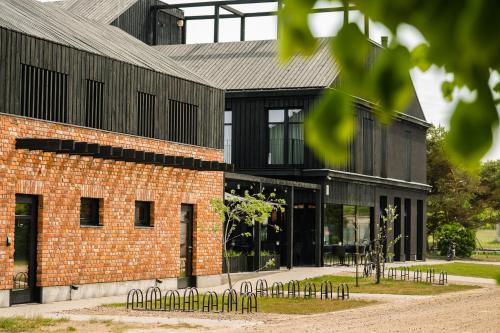 a red brick building with black windows at OTTO Hotel & Sun in Pāvilosta