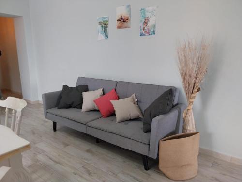 a gray couch with pillows in a living room at Domus DELEDDA in Posada