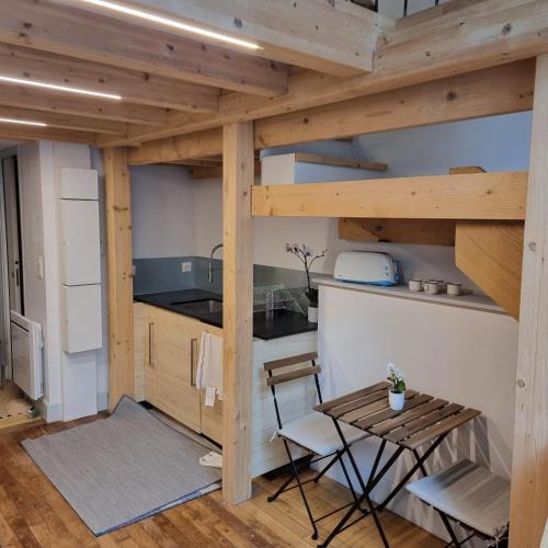 une cuisine avec une table et des chaises dans une pièce dans l'établissement Coq bleu, à Reims