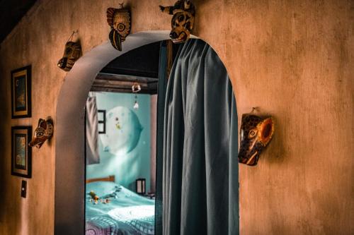 an archway in a room with a bed and a mirror at Baraka Antigua in Antigua Guatemala