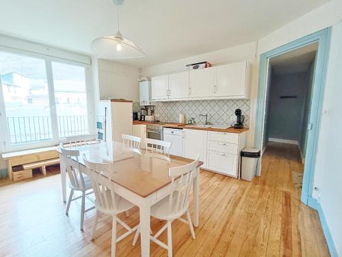 une cuisine avec une table et des chaises dans une pièce dans l'établissement Alphonse 52, grand T4, terrasse, wifi, 6 personnes, à Luchon