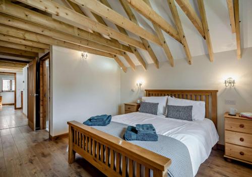 a bedroom with a large bed with two towels on it at Barley Barn in Kimberley