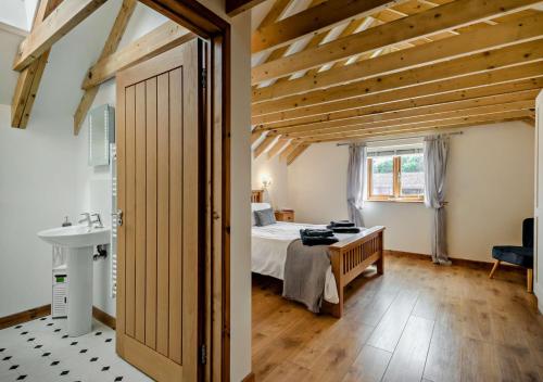 a bedroom with a bed and a desk and a sink at Barley Barn in Kimberley